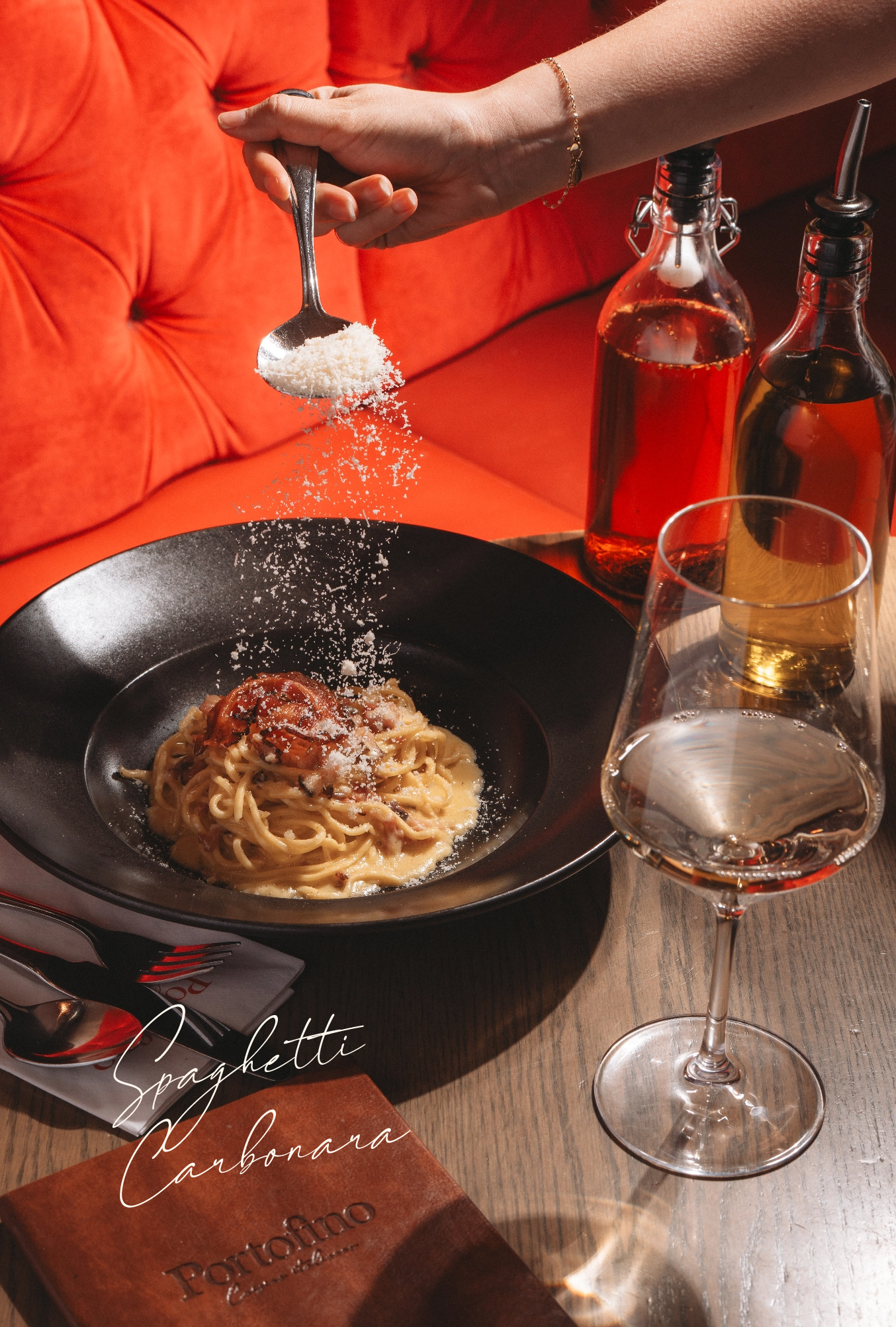 une personne parsemant du parmesan sur des pâtes